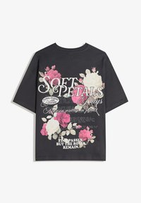 Fekete rövid ujjú pamut póló színes virágmintákkal és szöveggel. Figyelemre méltó a művészi betűk és rétegzett virágminták alkotta dizájn.
