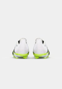 Des crampons de football avec une tige blanche texturée, des accents noirs et des crampons vert fluo. Présente une forme profilée et un support au niveau du talon arrière.