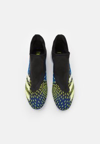 Modré a žluté atletické boty s designem podobným ponožce, texturovaným svrškem a černými akcenty. Vyznačují se bezproblémovou konstrukcí a živými vzory.