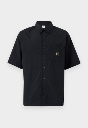 Chemise noire à manches courtes avec boutons, en tissu léger, dotée d'une poche poitrine et d'un détail en or avec le logo "GAP".