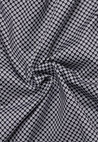 Zwart-wit gestreepte stof met een geometrisch ontwerp met kleine hexagonale vormen, een gladde textuur en een strakke binding.