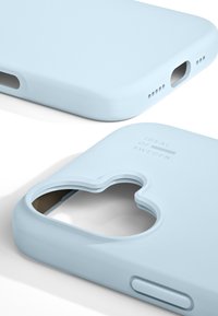 Lys blå smarttelefondeksel med matt finish. Har utskjæringer for kamera og knapper, med diskret merkevare på baksiden.