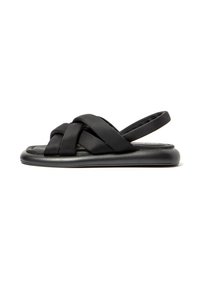 Sandalias negras con correas de tela cruzadas, parte trasera abierta, suela plana y plantilla acolchada. Presentan un diseño minimalista y una textura suave.
