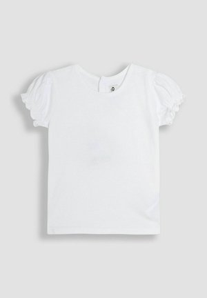 Balta trumpa rankovėmis marškinėliai su pūstomis rankovėmis, apvaliu iškirpimu ir mažai mygtuko detale nugaroje. Slydūs medvilniniai audiniai, paprastas ir švarus dizainas.