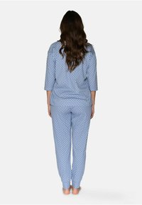 Blå mönstrad pyjamasuppsättning med diamantdesign, trekvartslånga ärmar och lösa byxor, tillverkad av mjukt tyg för komfort.