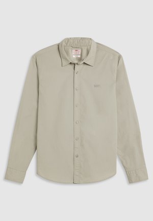 Camisa de manga larga gris claro hecha de algodón, con cuello abotonado, tapeta frontal con botones y un pequeño logo bordado en el pecho.
