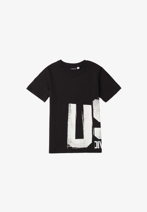 Schwarzes Baumwoll-T-Shirt mit kurzen Ärmeln, das ein großes, weißes, stark abgenutztes Grafikdesign mit "US" auf der Vorderseite zeigt. Klassischer Rundhalsausschnitt.