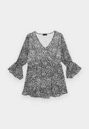 Blouse à motifs noir et blanc avec un décolleté en V, des manches longues évasées et une taille cintrée. Matière légère et transparente avec une silhouette fluide.