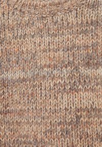 Neulottu villapaitakangas maanläheisissä ruskean ja beigen sävyissä, jossa on teksturoitu kuvio eri sävyillä ja hienovaraisilla oransseilla pilkuilla.