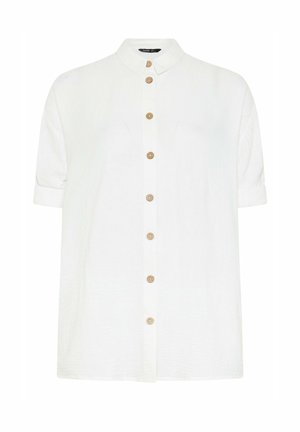 Camisa blanca de manga corta con botones de madera y cuello clásico, exhibida sobre un fondo liso.