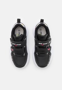 Zapatillas deportivas negras con suelas de goma blanca, correas de velcro y texto impreso colorido con patrones. Punta redondeada y cuello acolchado.