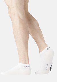 Chaussettes blanches à rabat en mélange de coton, avec un bord côtelé et un texte noir "39-42" et un accent "UM" sur le côté.