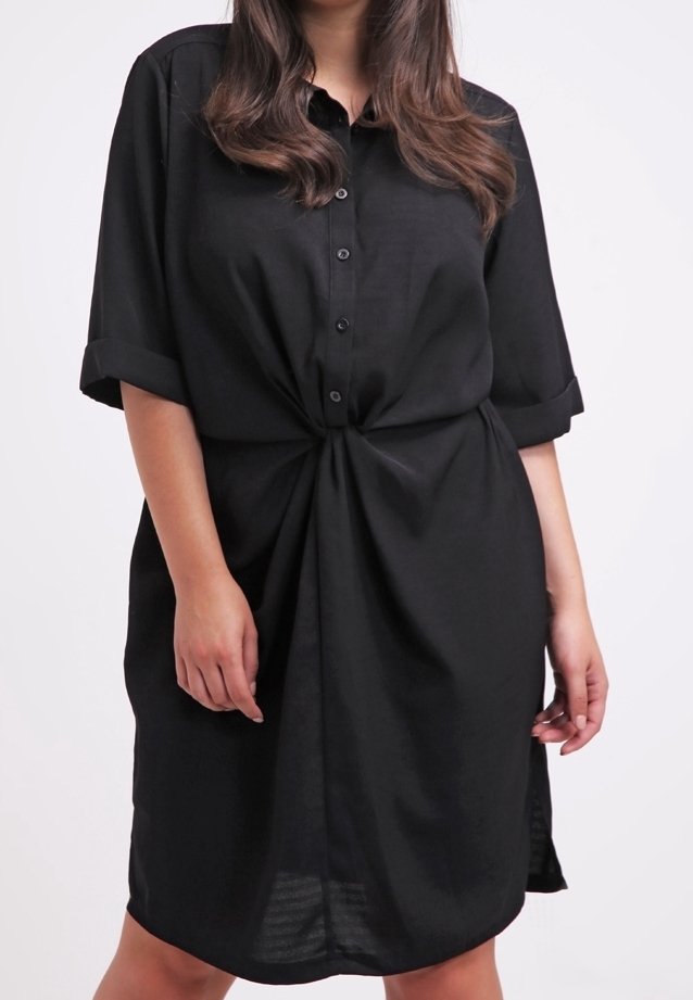 Robe-chemise noire en tissu léger, avec manches courtes retroussées, fermeture à boutons sur le devant et détail noué à la taille.