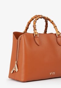 Borsa a tracolla in pelle marrone con una forma strutturata, manici in bambù e una cerniera dorata. Presenta un piccolo logo impresso sul lato.