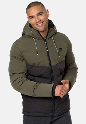 Veste matelassée avec un design bicolore en vert olive et noir, dotée d'une capuche, d'une fermeture éclair à l'avant et de cordons de serrage. Tissu texturé avec un détail de logo.