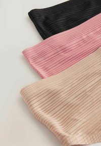 Ensemble de trois chouchous en tissu côtelé de couleur noire, rose et nude. Chacun présente une texture douce et des rayures subtiles variées.