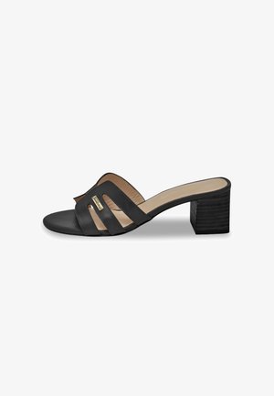 Mule nera con tacco realizzata in pelle liscia, tre fascette intagliate e un tacco cubo testurizzato. Fodera interna in beige.