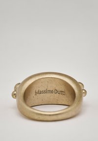 Goldfarbener Metallring mit glatter Textur, runder Form und zwei kleinen dekorativen Akzenten auf jeder Seite; graviert mit "Massimo Dutti."