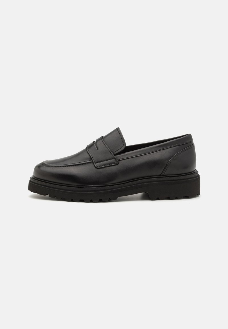 Black leather loafer with a round toe, stitched detailing, and a thick, textured sole. Features a sleek, minimalist design.