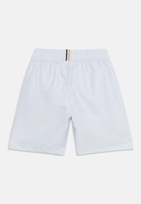 Φωτεινά γαλάζια σορτς με ελαστική μέση και μικρή κάθετη λεπτομέρεια μαύρης και καφέ ρίγας στο κεντρικό πίσω μέρος της ζώνης μέσης.