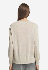 Helle beigefarbene Sweater mit einer lockeren Passform, rundem Ausschnitt und langen Ärmeln. Gerippter Saum und Bündchen. Weiche Textur, minimalistisches Design.