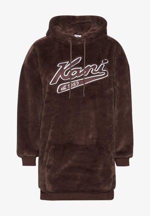 Brun fluffig huvtröja med en stor framficka, prydd med vit broderad text "Kani est. 1989" på bröstet. Mjuk textur.