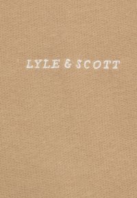 Beige fabric with a ribbed texture, featuring the white embroidered text "LYLE & SCOTT" centered near the bottom.