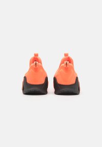 Neon orange sportsko med en sort sål, der har en afrundet bagdesign, trækremme og teksturerede overflader for greb og støtte.