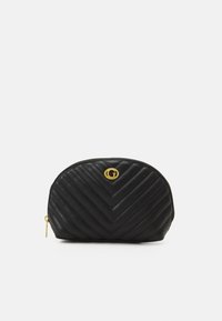 Borsetta in pelle nera con imbottitura a chevron, logo circolare dorato sulla parte anteriore, forma arrotondata e chiusura con zip superiore.