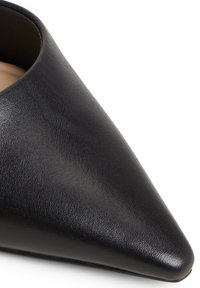 Black leather pointed-toe shoe with a smooth texture and minimalistic design. Features a sleek silhouette and a low-cut opening.