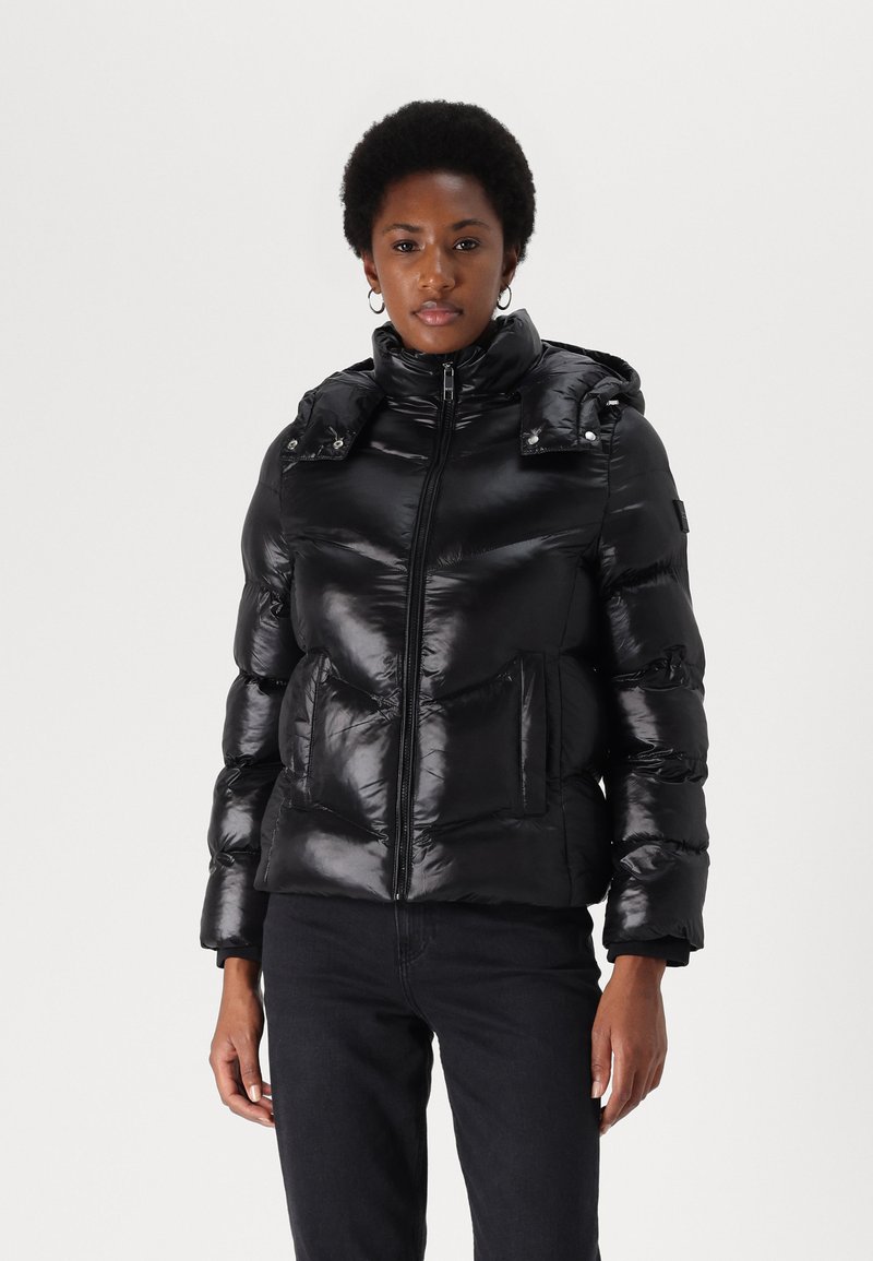 Black puffer jacket with a shiny finish, zip closure, detachable hood, and two front pockets. Features stitched panels for added texture.