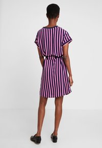 Vestido a rayas en azul marino, rosa y blanco, con un ajuste holgado, mangas cortas y una cintura ceñida; tela suave con un brillo sutil.