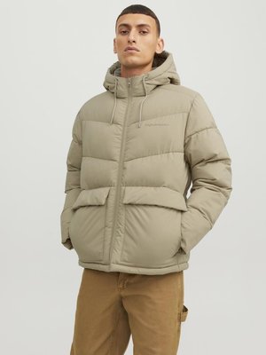 Chaqueta de plumas beige con capucha, cierre frontal, dos grandes bolsillos frontales y cordones ajustables, diseñada con una textura acolchada.