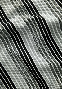 Tela a rayas en blanco y negro con líneas de diferentes anchos y texturas, con un aspecto suave y tejido.