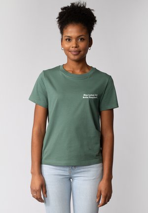T-shirt en coton vert avec un col rond et des manches courtes. Il présente le texte blanc "Das Leben ist kein Ponyhof" sur le devant.
