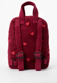 Sac à dos en velours côtelé rouge avec des motifs de cœurs. Dispose de deux bretelles et d'une petite poignée en haut. Surface texturée et boucles réglables.