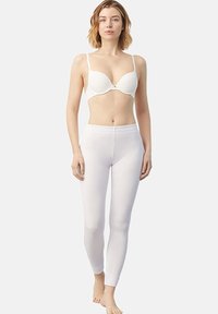 Conjunto de ropa interior blanca que presenta un sujetador moldeado y suave con tirantes ajustables y leggings de talle alto en una tela suave y elástica.