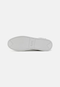 White rubber sole with rounded edges and textured pattern. Features a central logo, smooth surface, and a slight heel for added grip.