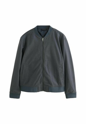 Giubbotto bomber verde scuro con collo rotondo, zip frontale, due tasche laterali e polsini e orlo a costine. Tessuto liscio e strutturato.