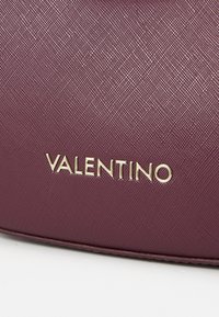 Geantă texturată burgundy cu logo-ul "VALENTINO" auriu, având un design elegant, rectangular și un finisaj neted.