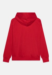 Sudadera roja con capucha ajustable, puños y dobladillo acanalados, y una textura suave. El diseño es simple, sin patrones visibles.