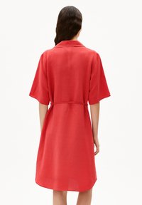 Rotes, kurzärmeliges Kleid aus leichtem Stoff. Verfügt über einen Hemdkragen und einen taillierten Bund, mit geradem Rückenteil und abgerundetem Saum.