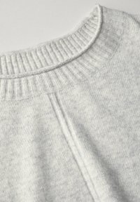 Pull en gris clair avec un col côtelé, texture douce et design simple. Caractérisé par des détails minimaux et une coupe décontractée.