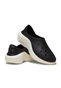 Czarne chodaki o gładkiej, matowej powierzchni, z otworami wentylacyjnymi, kontrastującą kremową podeszwą i zaokrąglonym kształtem dla komfortu.