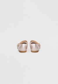 Rosa metallische Ballerinas mit runden Zehen, niedrigem Absatz und Schleifenakzenten auf der Rückseite, die eine glatte Textur und ein weiches Innenfutter aufweisen.
