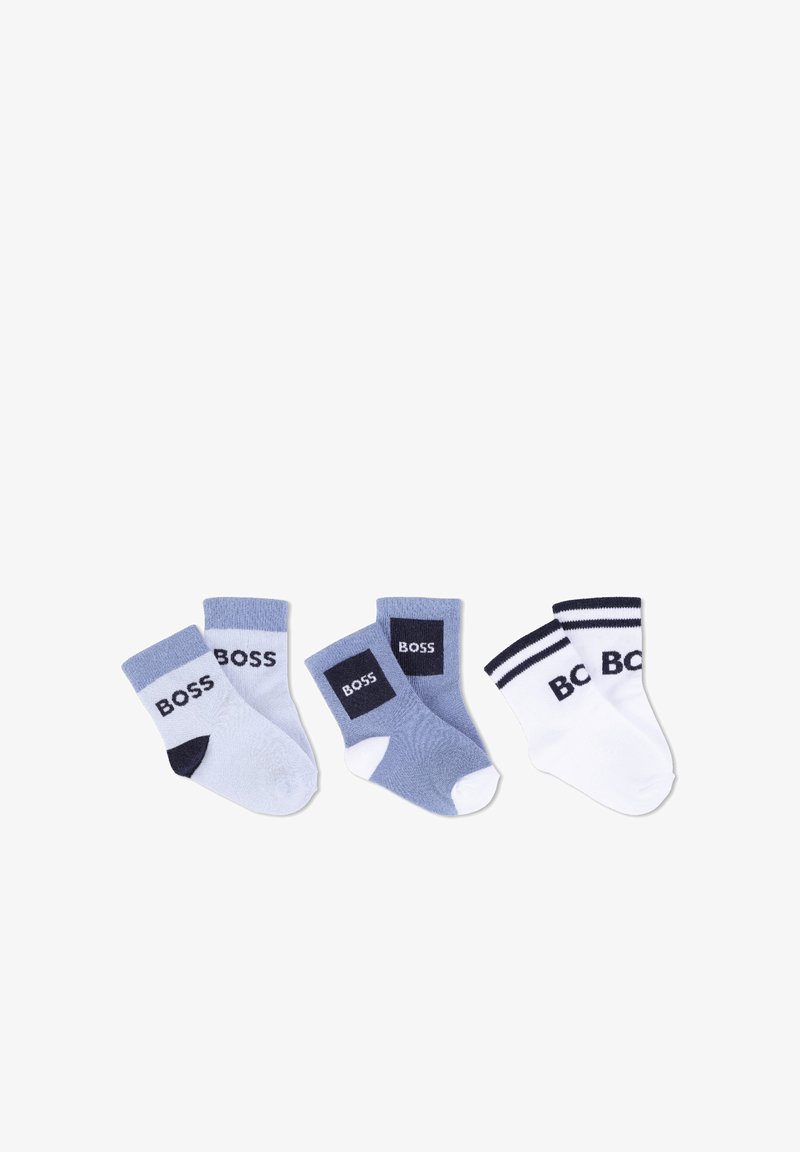 Trois paires de chaussettes pour bébé en bleu, bleu clair et blanc, chacune avec la marque "BOSS" et des détails contrastants aux orteils ou aux bords.