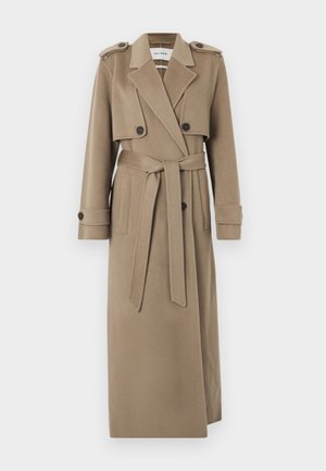 Trench-coat beige long avec épaulettes, rabat pare-tempête boutonné, taille ceinturée et poignets de manche boutonnés.