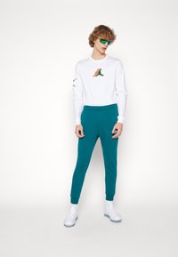 Nike Sportswear CLUB JGGR - Tracksuit bottoms - geode teal/white