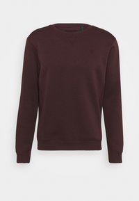 Felpa bordeaux realizzata in morbido tessuto, con scollatura a girocollo, polsini e orlo a costine, e un logo discreto sul petto.