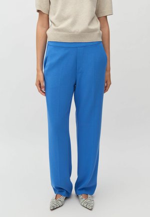 Blue, tailored trousers with a straight cut and waistband, made from smooth fabric. Pair worn with black and white striped pointed shoes.